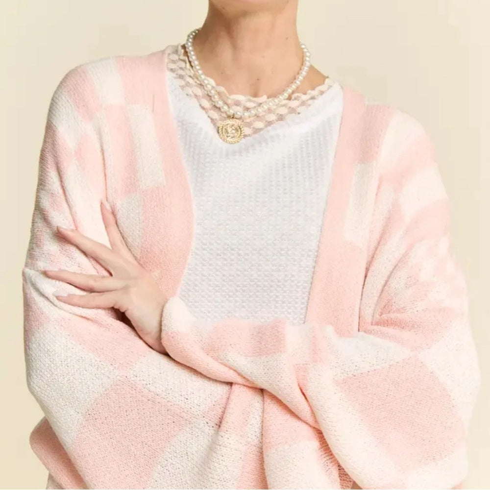 Person wearing a pink and white patterned shawl over a white top on a beige background