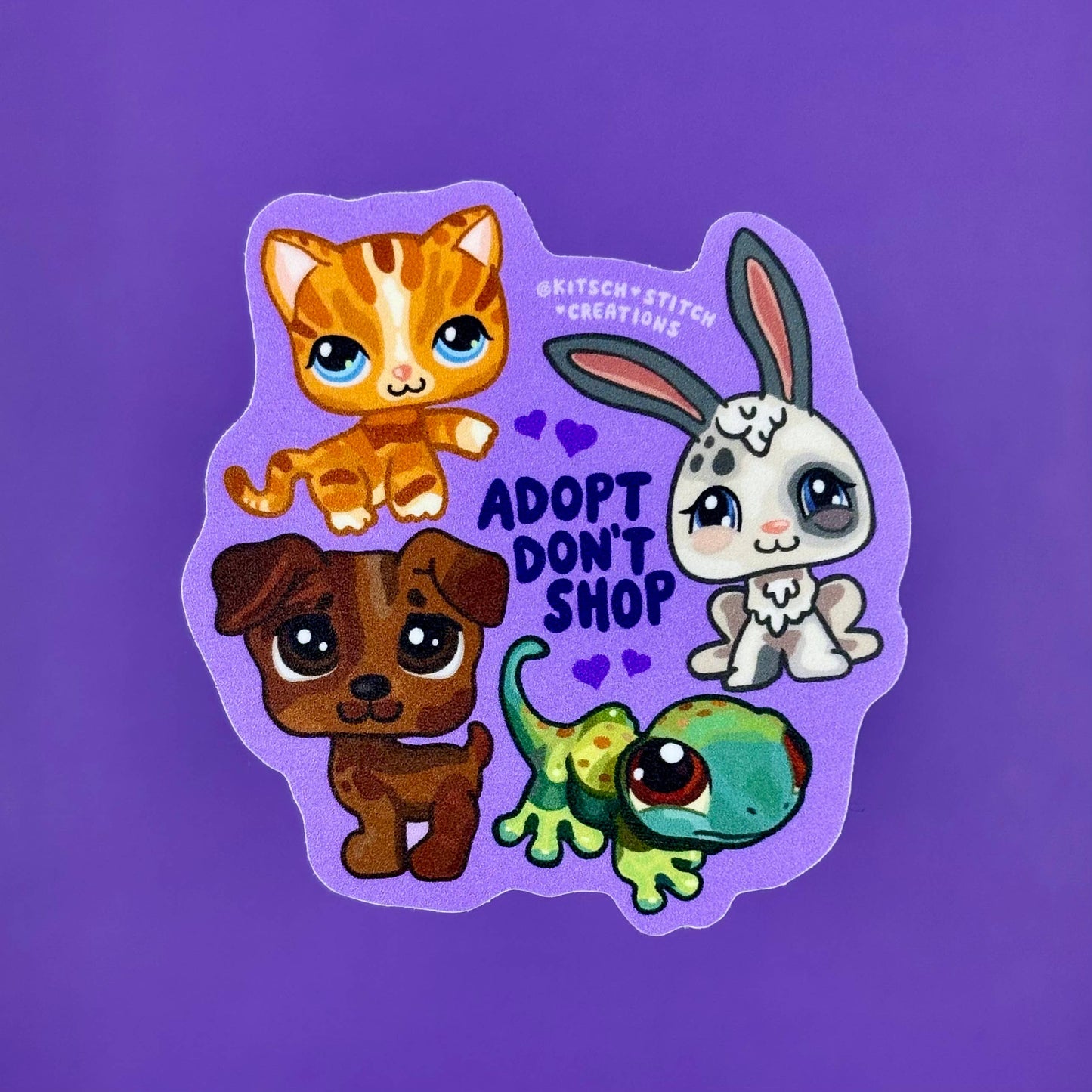 Sticker with cartoon animals and 'Adopt Don't Shop' text on a purple background
