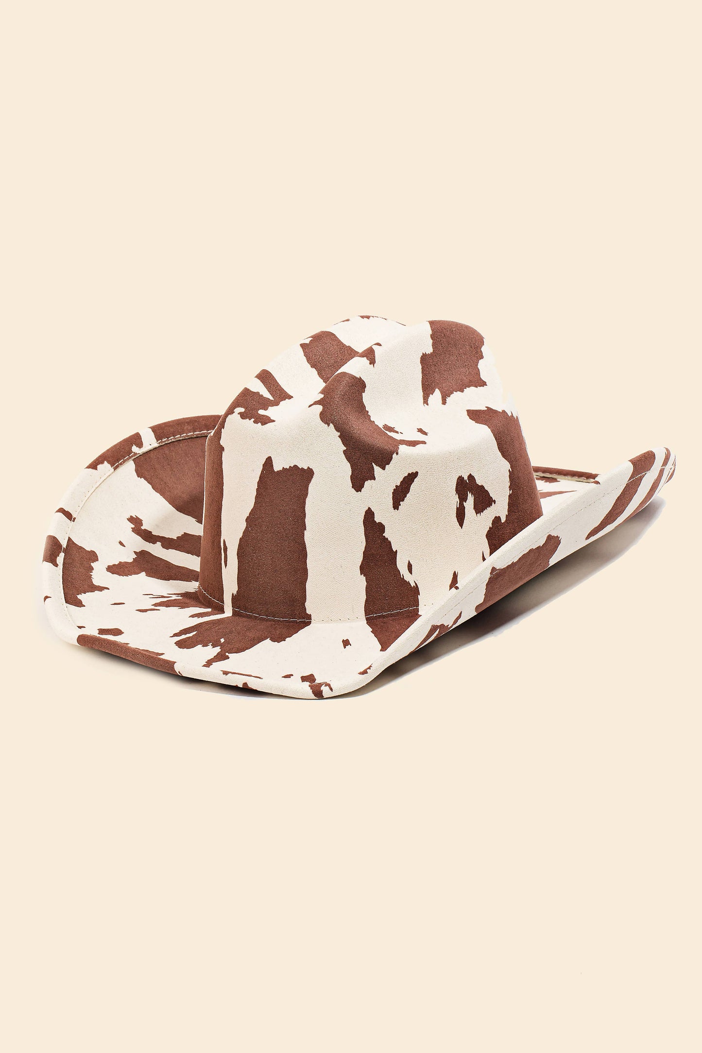 Cow print cowboy hat on a beige background