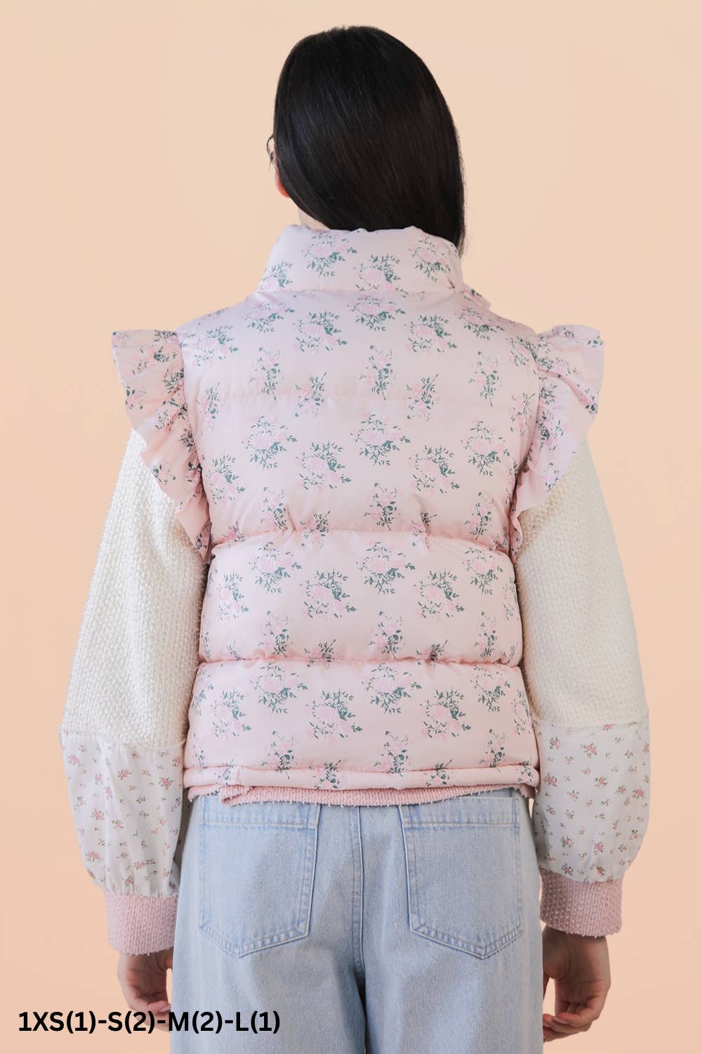 back pink floral puffer vest on model with brown hair on a beige background 