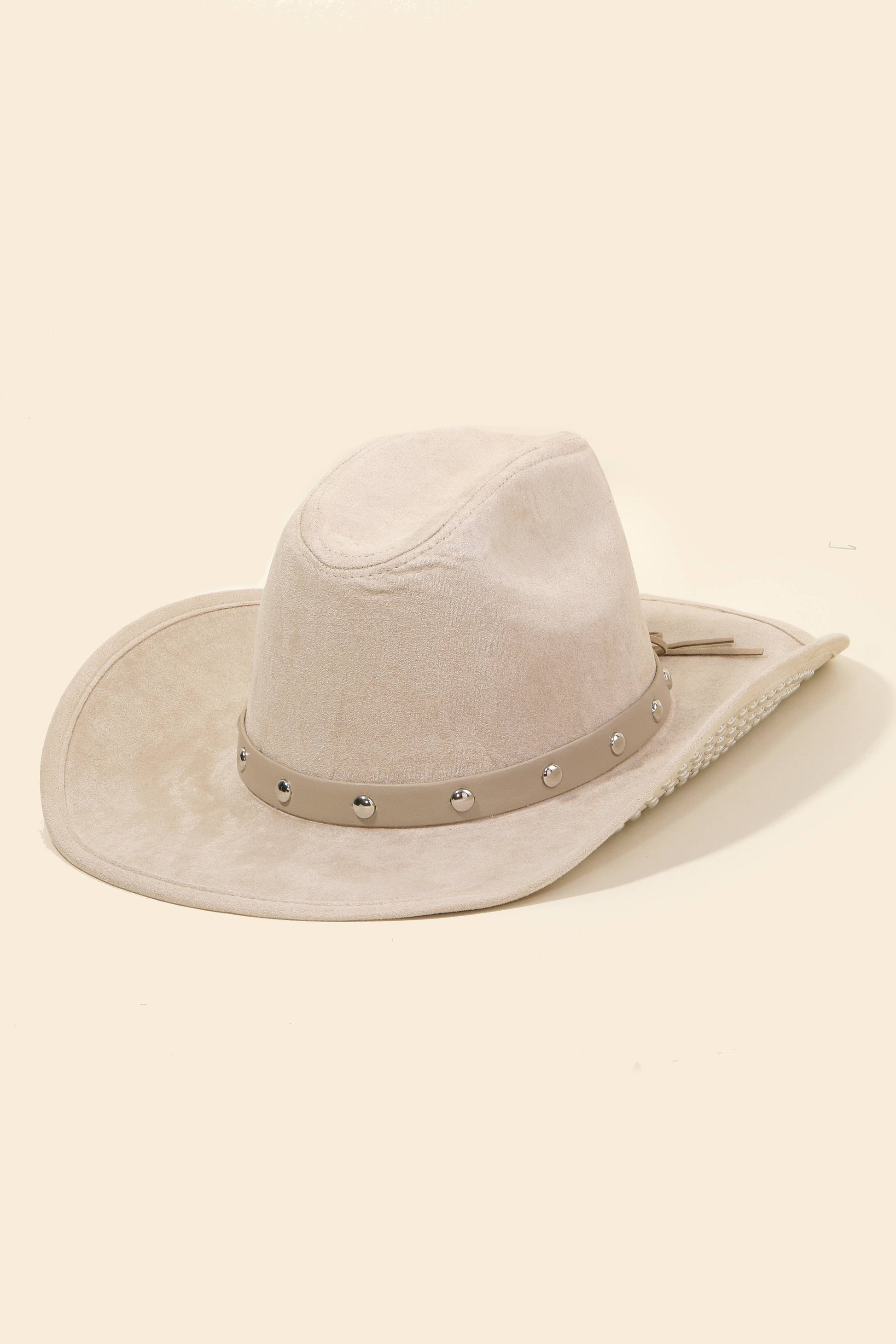 Beige cowboy hat with a band on a beige background