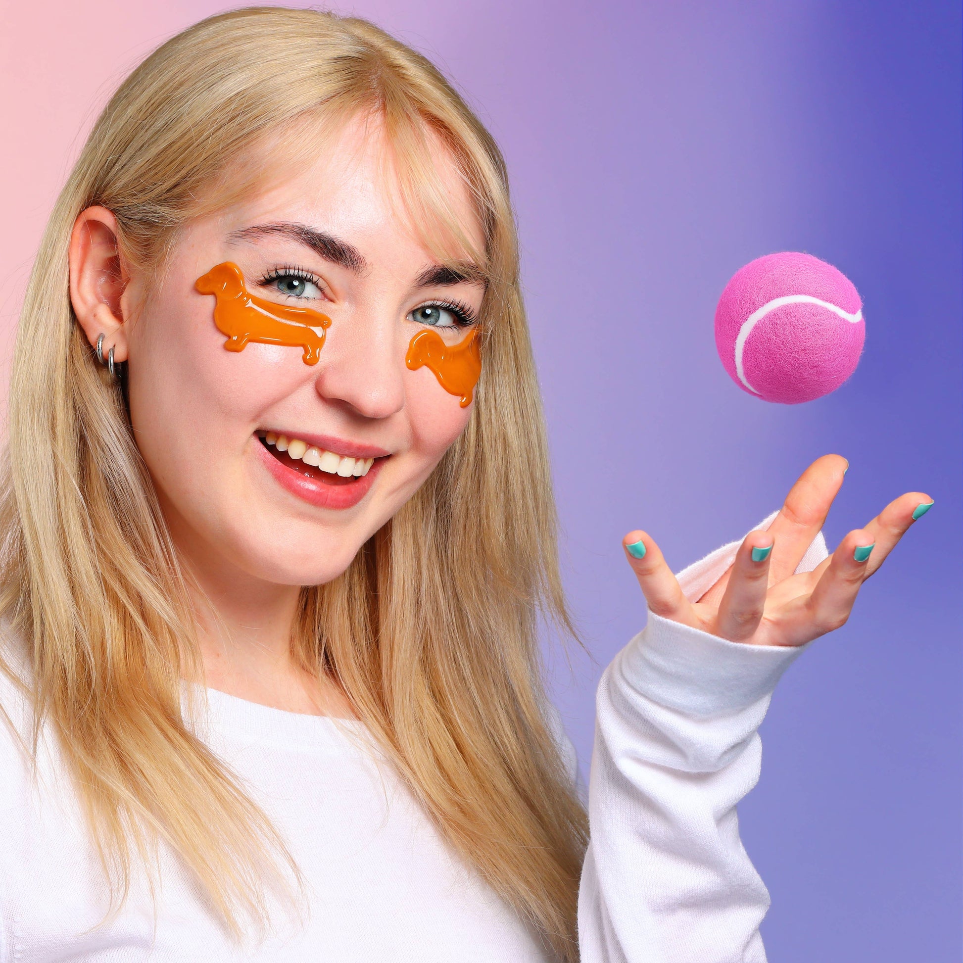 Woman with brown dog eye masks holding a pink tennis ball against a gradient background