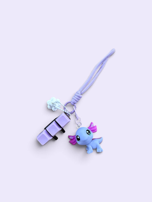 A light purple phone strap charm featuring a small blue cartoon creature with pink wings and a matching purple pouch, set against a pale lavender background.