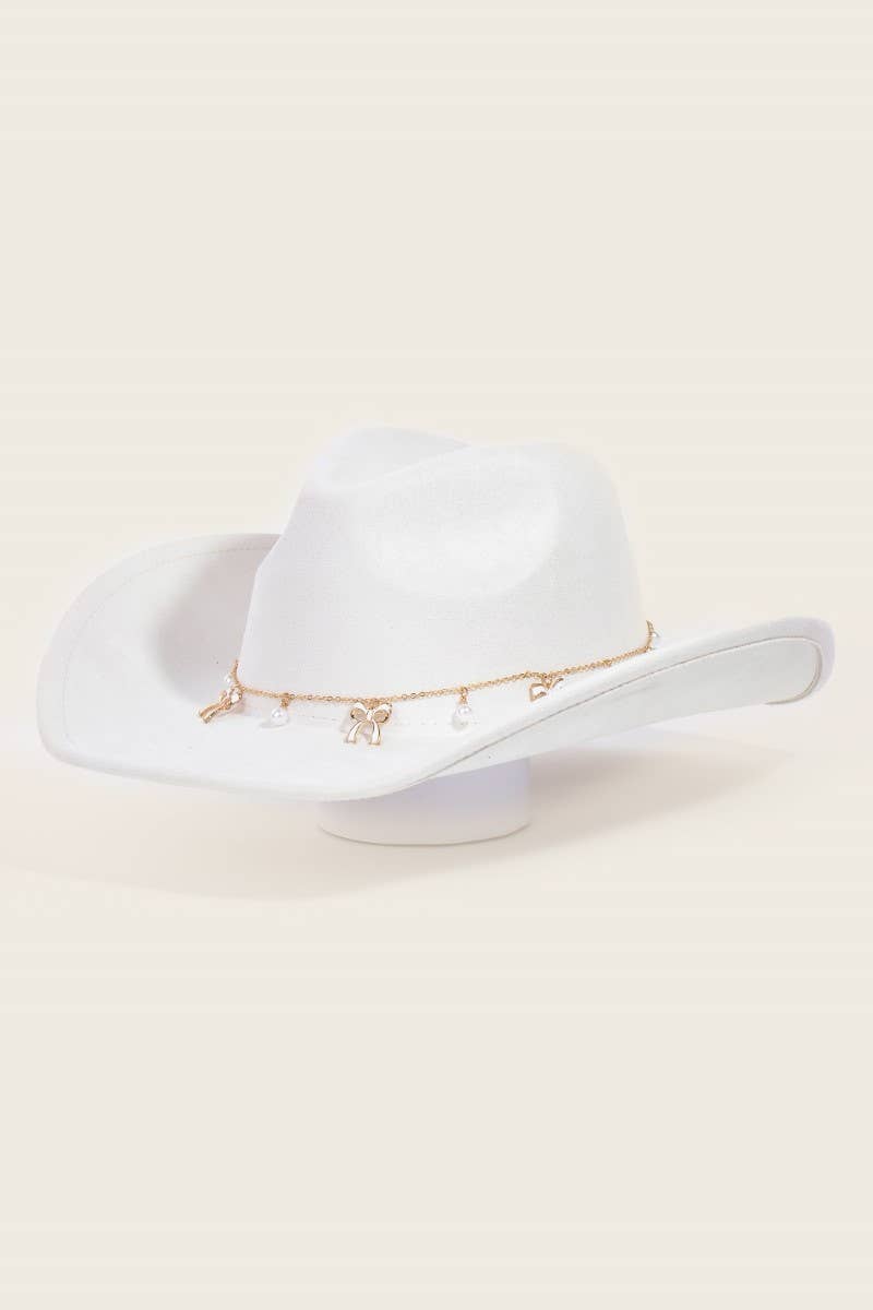 White cowboy hat with gold band on a beige background