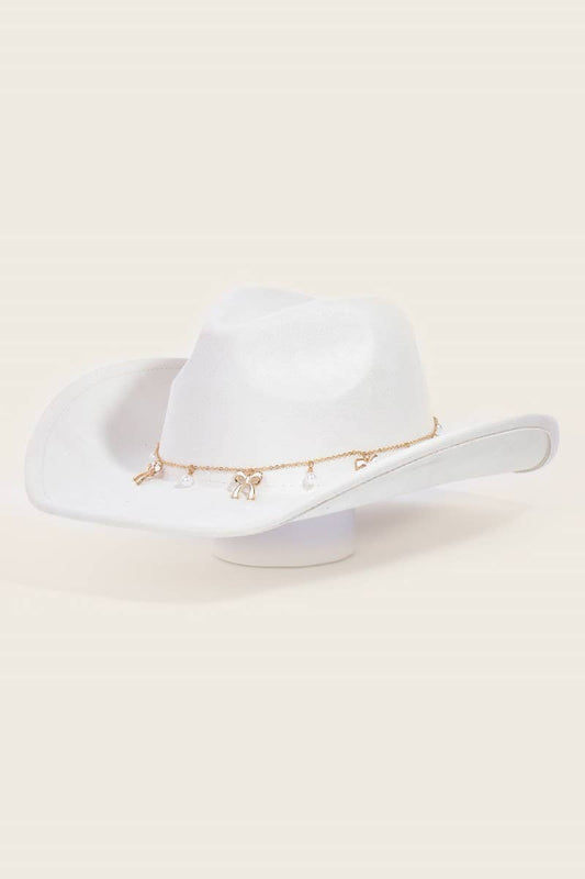 White cowboy hat with gold band on a beige background