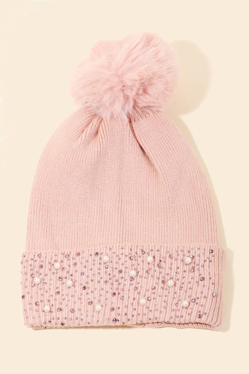 Pink Pom beanie with rhinestones and pearls on a beige background