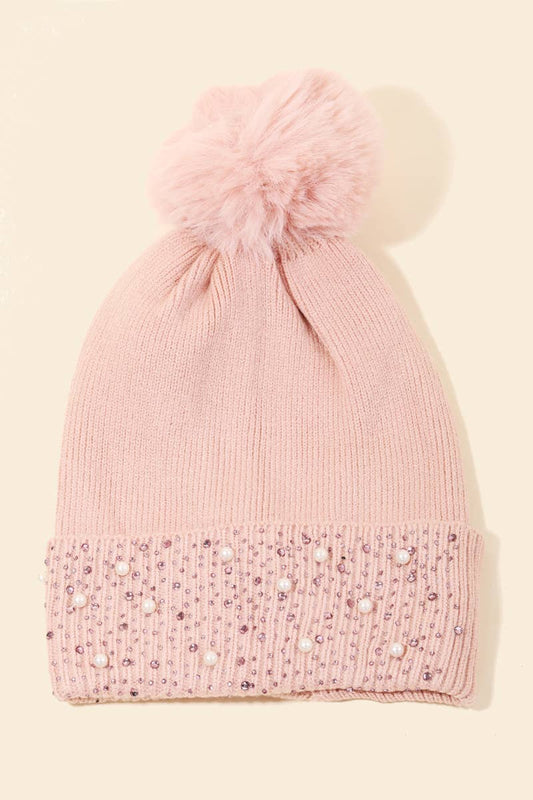 Pink Pom beanie with rhinestones and pearls on a beige background