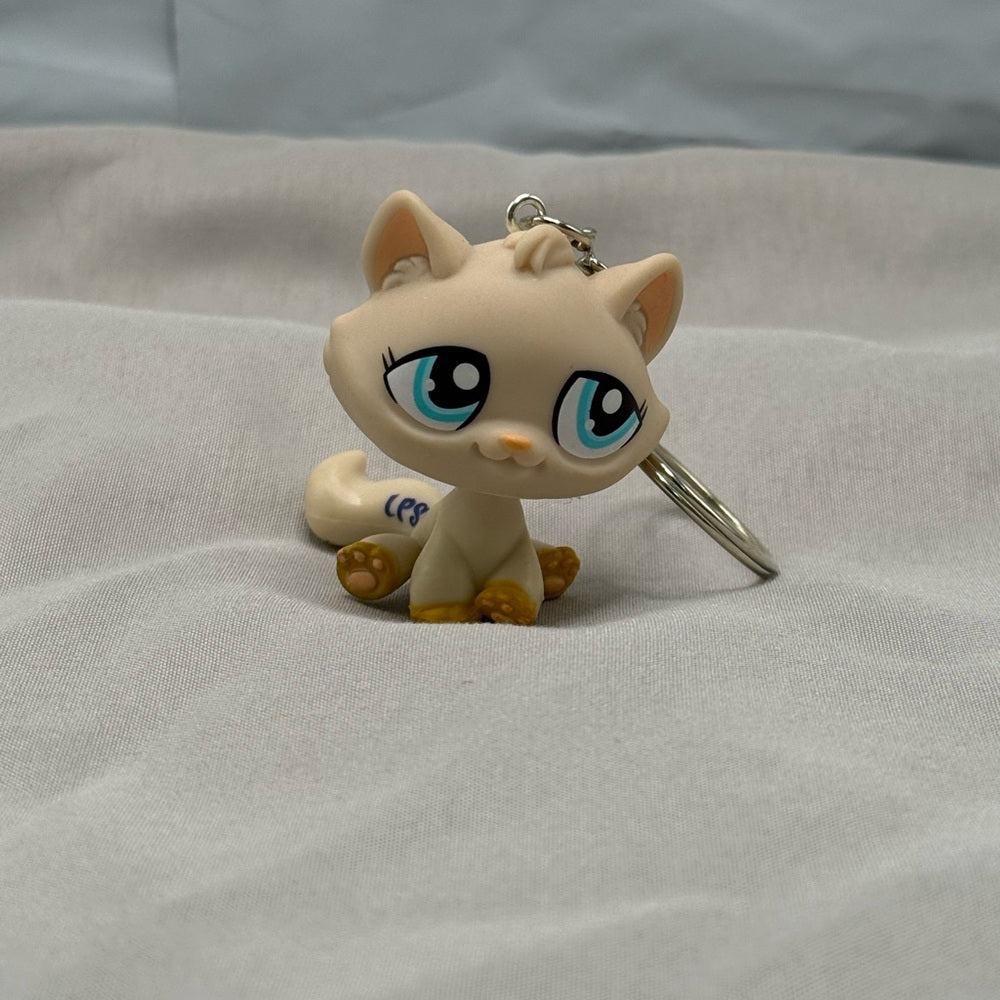 Littest Pet Shop cat keychain sitting on blanket 