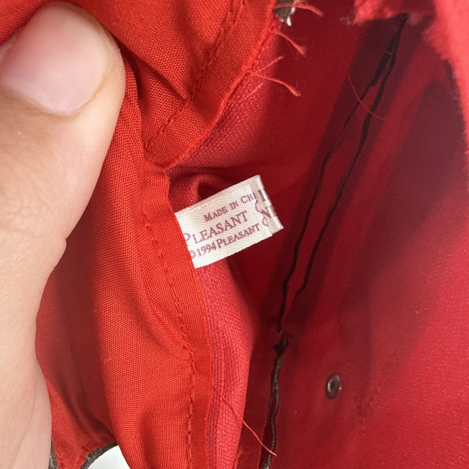 Close-up of a red fabric label with text on a red background