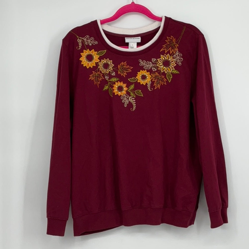 Maroon sweatshirt with floral embroidery on a white background