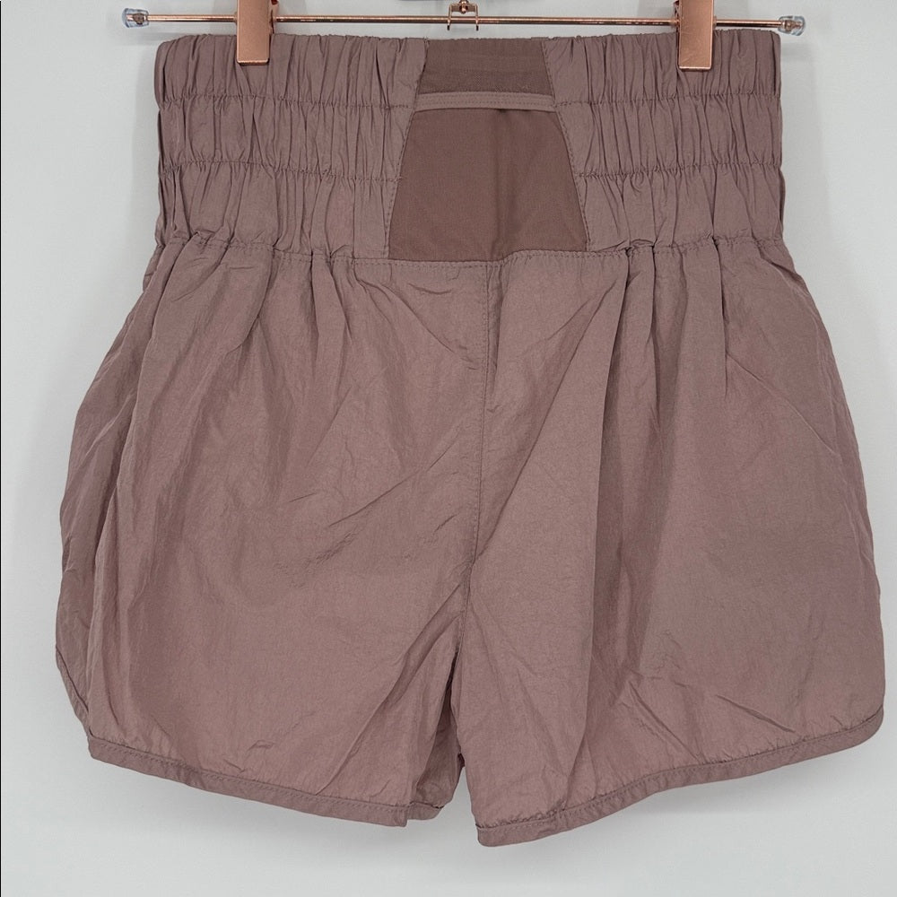 Brown shorts on a hanger against a white background