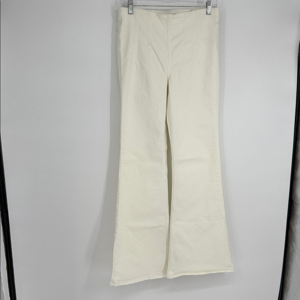 White pants hanging on a rack against a gray background