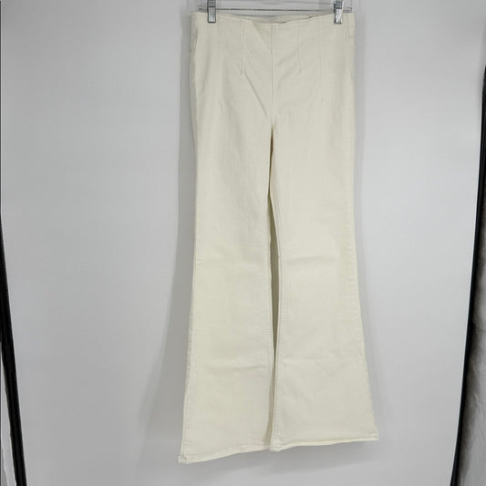 White pants hanging on a rack against a gray background