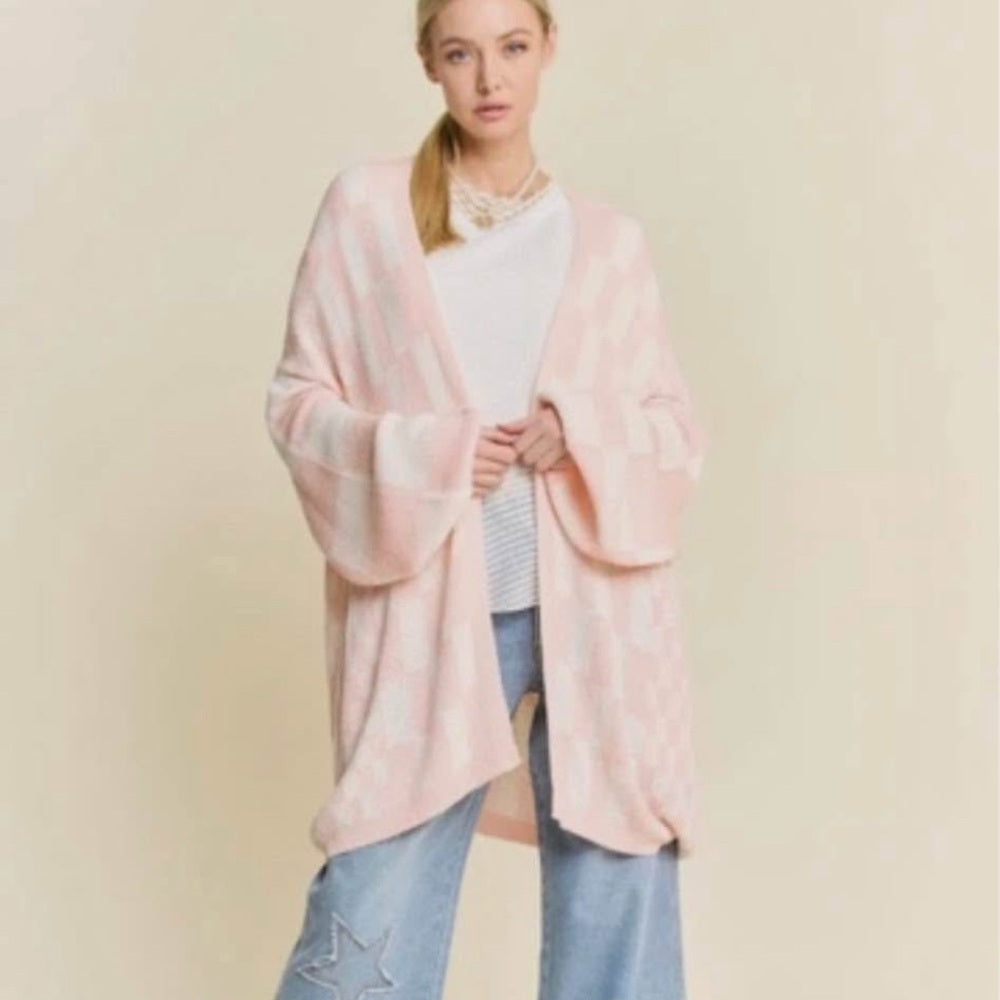 Woman wearing a pink kimono-style garment against a beige background