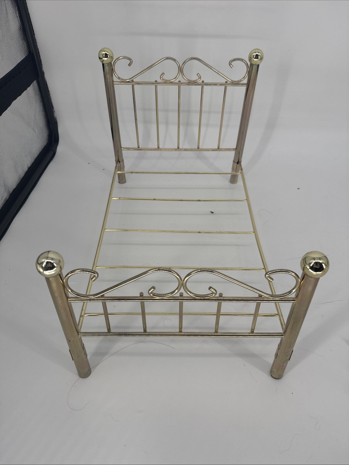 Small gold metal bed frame on a white background