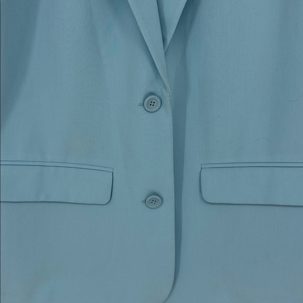 Close-up of a light blue shirt with buttons and pockets