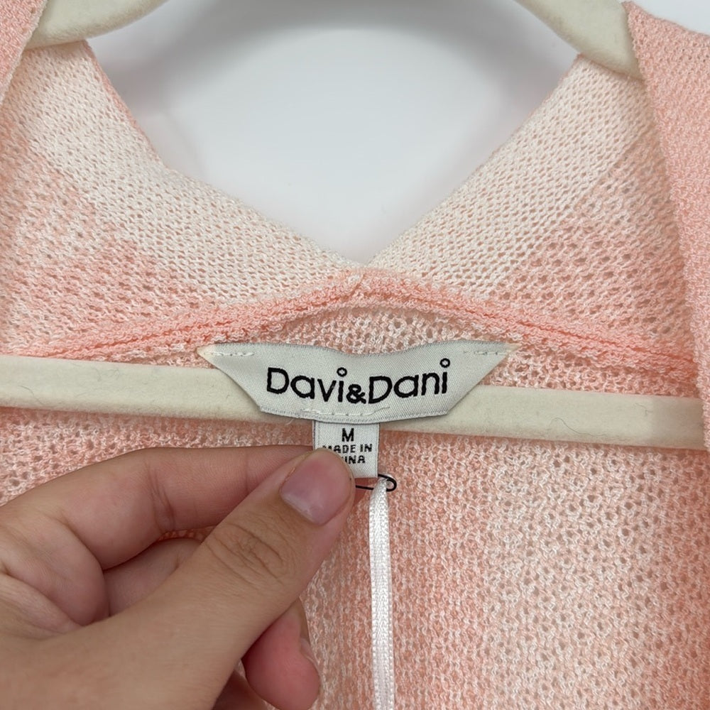 Pink garment with a 'Davi&Dani' label held by a hand.