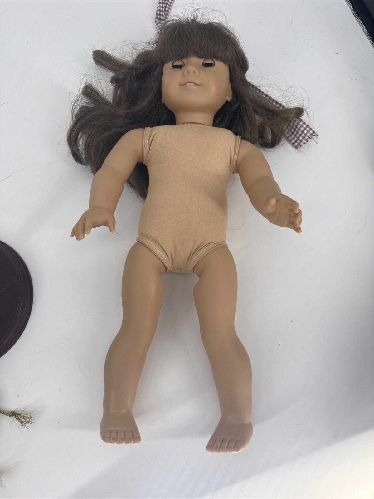 Plain doll with brown hair on a white background