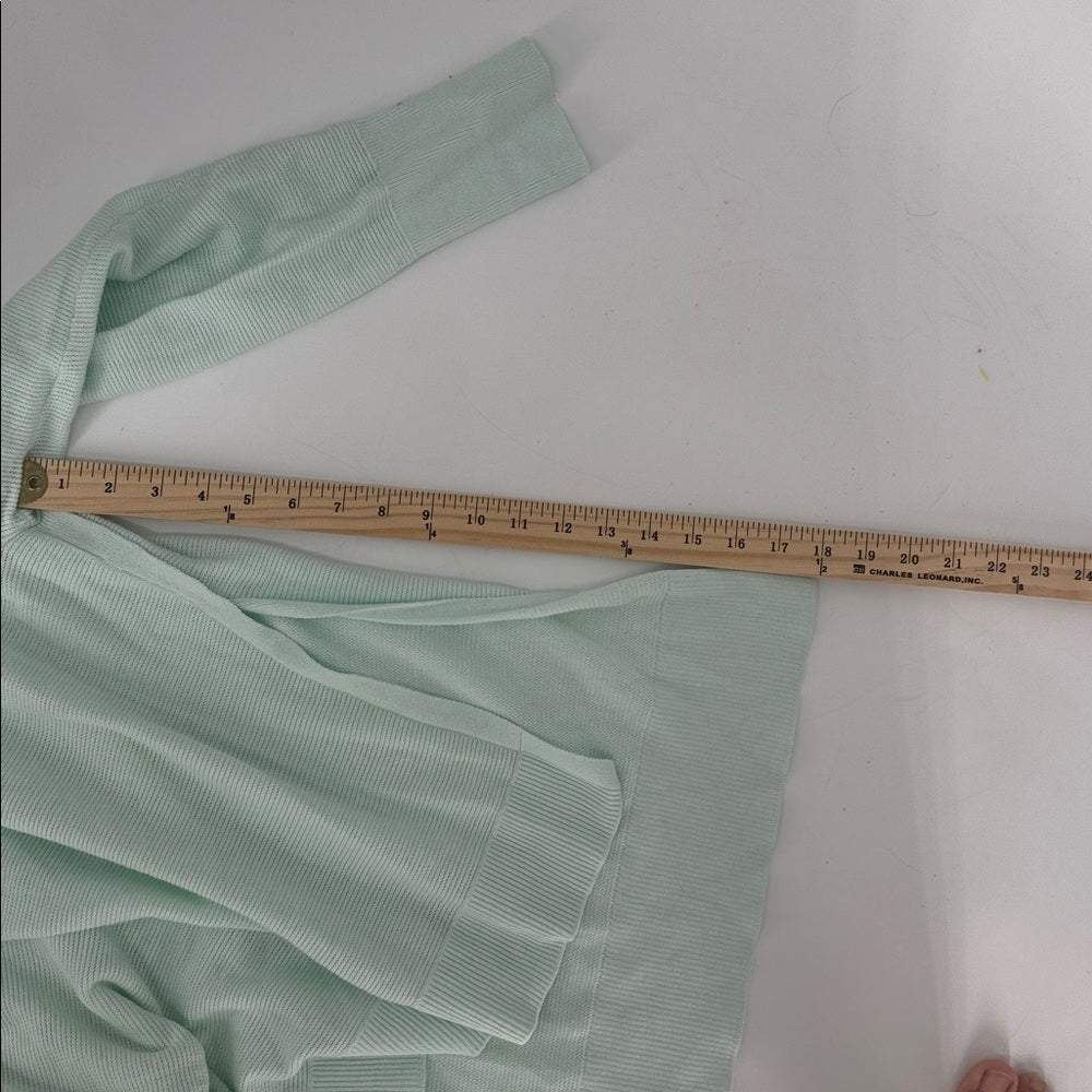 Light green fabric with a wooden ruler on a white background