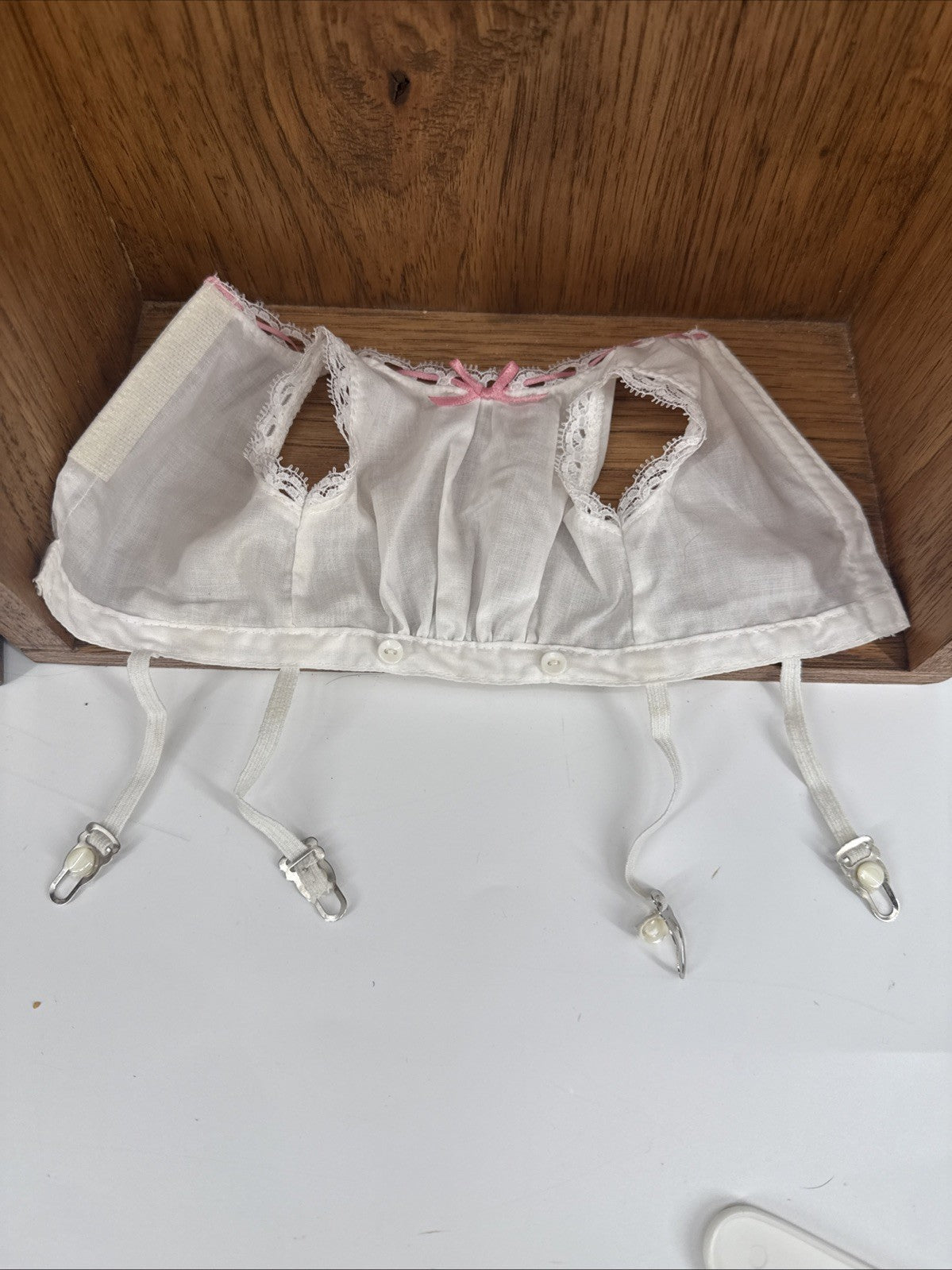 White lace bra with suspenders on a wooden surface