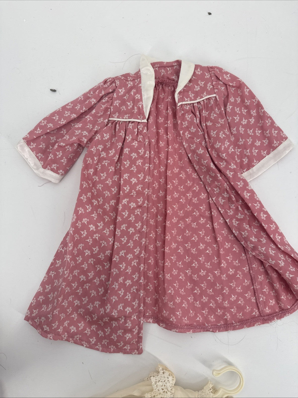 Pink floral dress with white trim on a light gray background