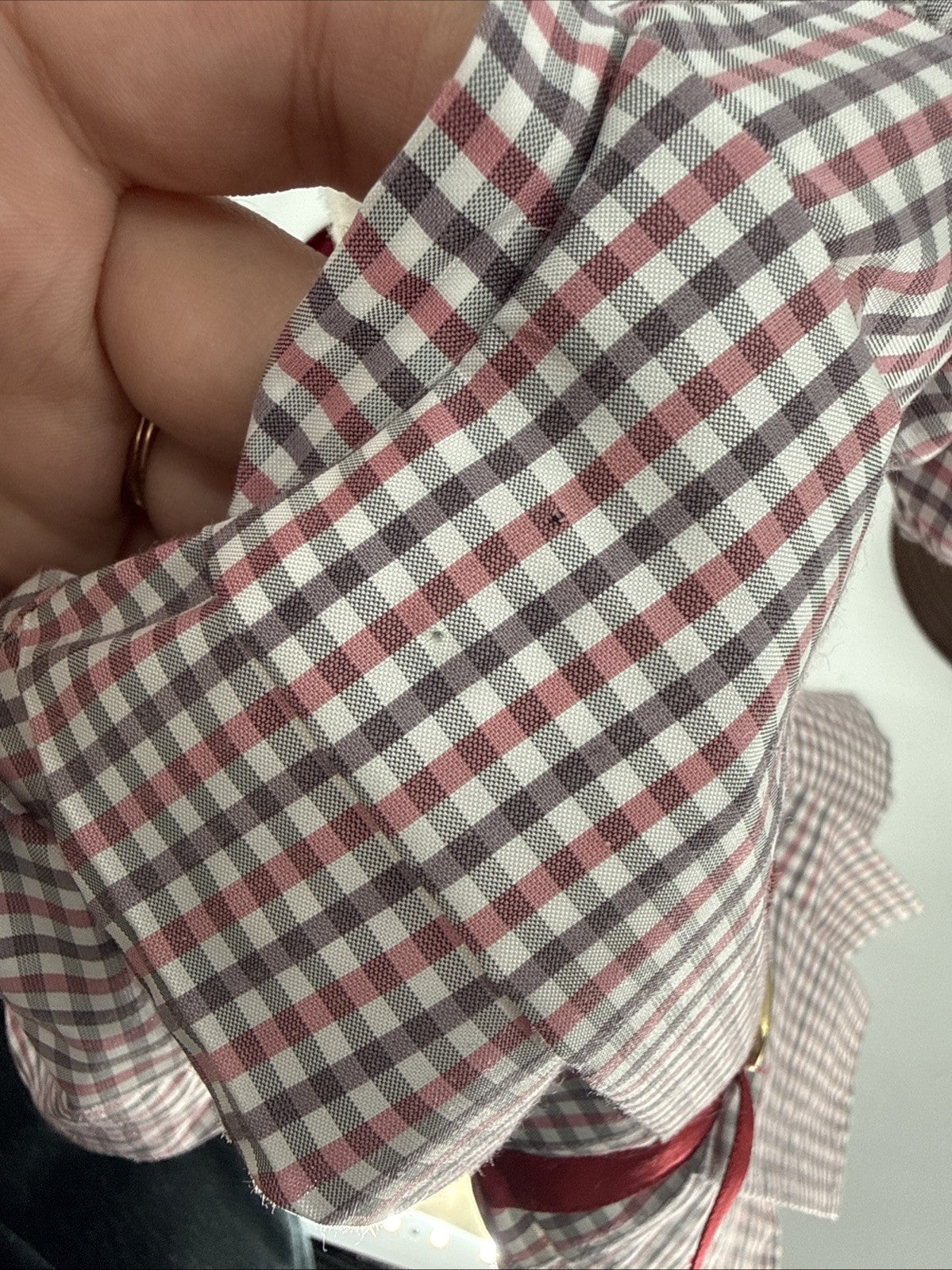 Close-up of a checkered fabric with two small pin holes red and white pattern