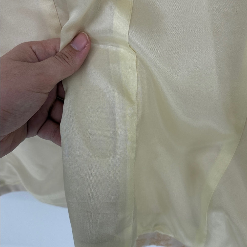 Close-up of a hand holding beige fabric with a blurred background