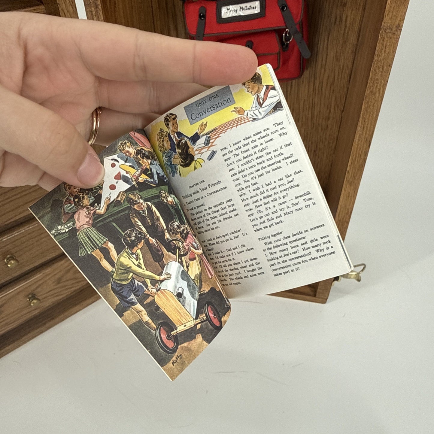 Vintage-style postcard with colorful illustrations and text held by a hand.