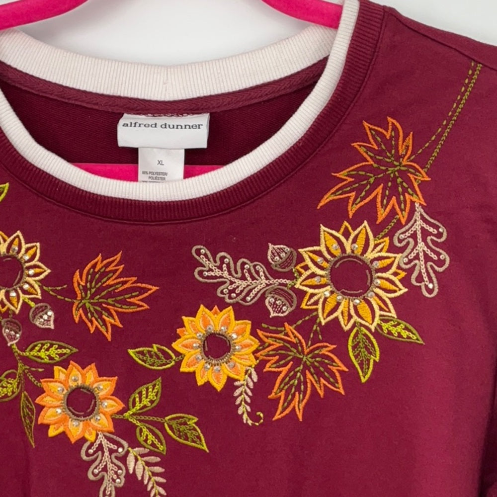 Maroon sweatshirt with floral embroidery on a mannequin, brand 'alfred dunner' visible.