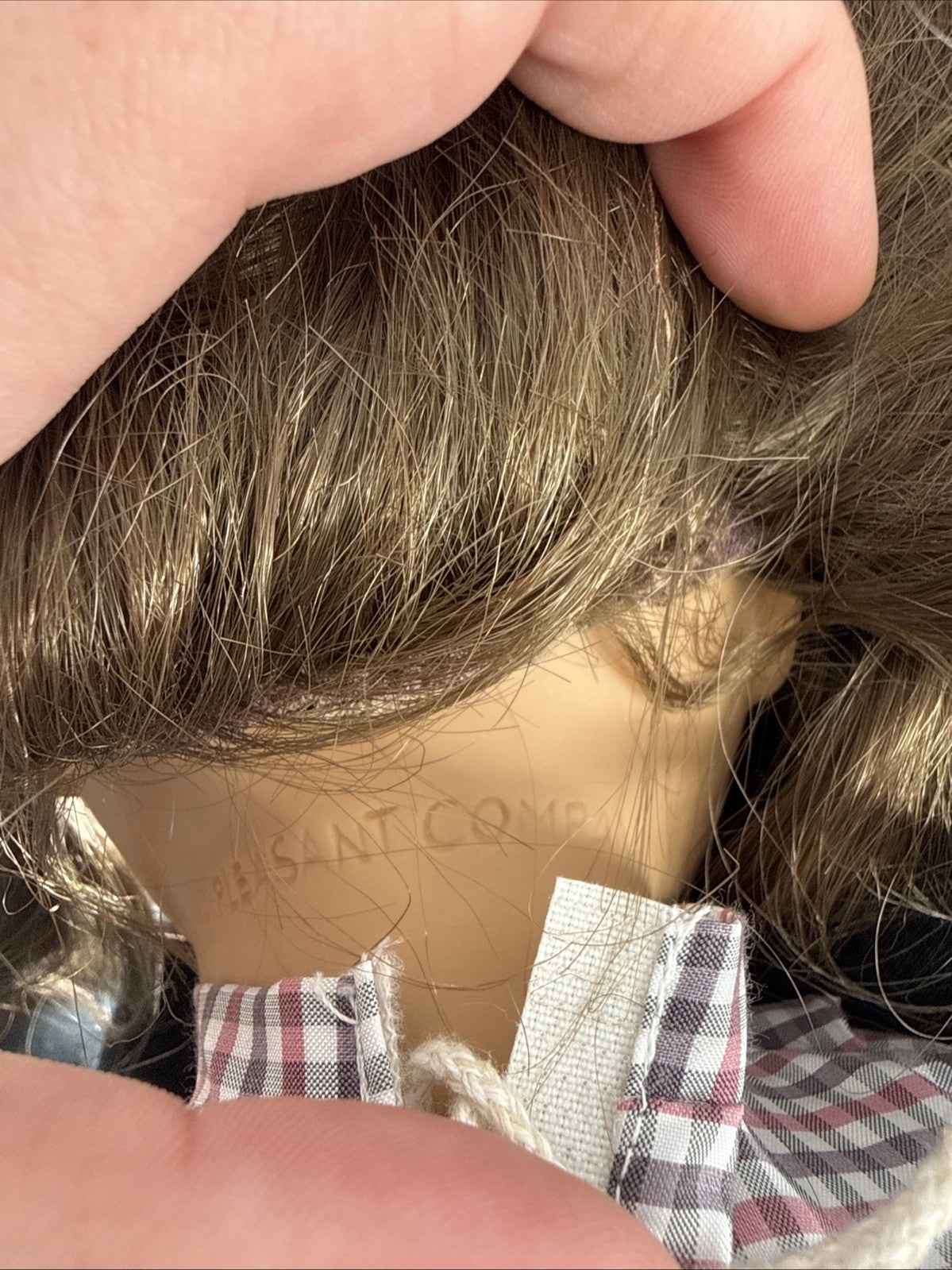 Close-up of a wig with a brand label on a mannequin head.