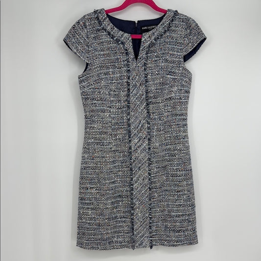 Black and gray patterned dress on a hanger against a white background