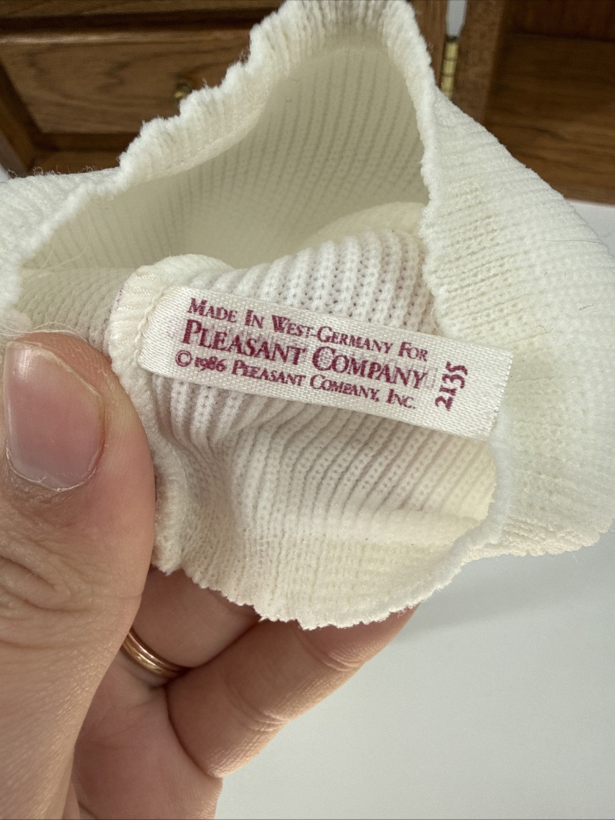 Textile product with a label indicating 'Made in West Germany for Pleasant Company' held by a hand.
