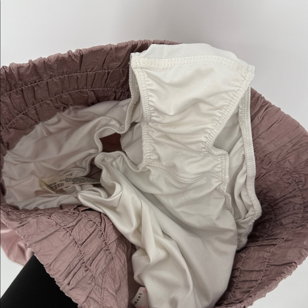 Close-up of a textured pink garment with a white lining on a light gray background