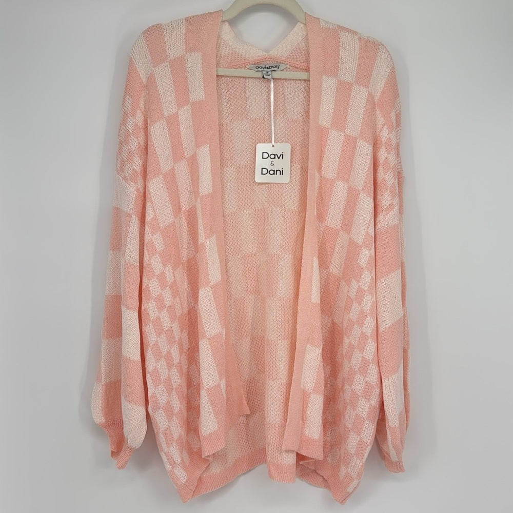 Pink patterned cardigan on a hanger with a visible brand tag against a plain background