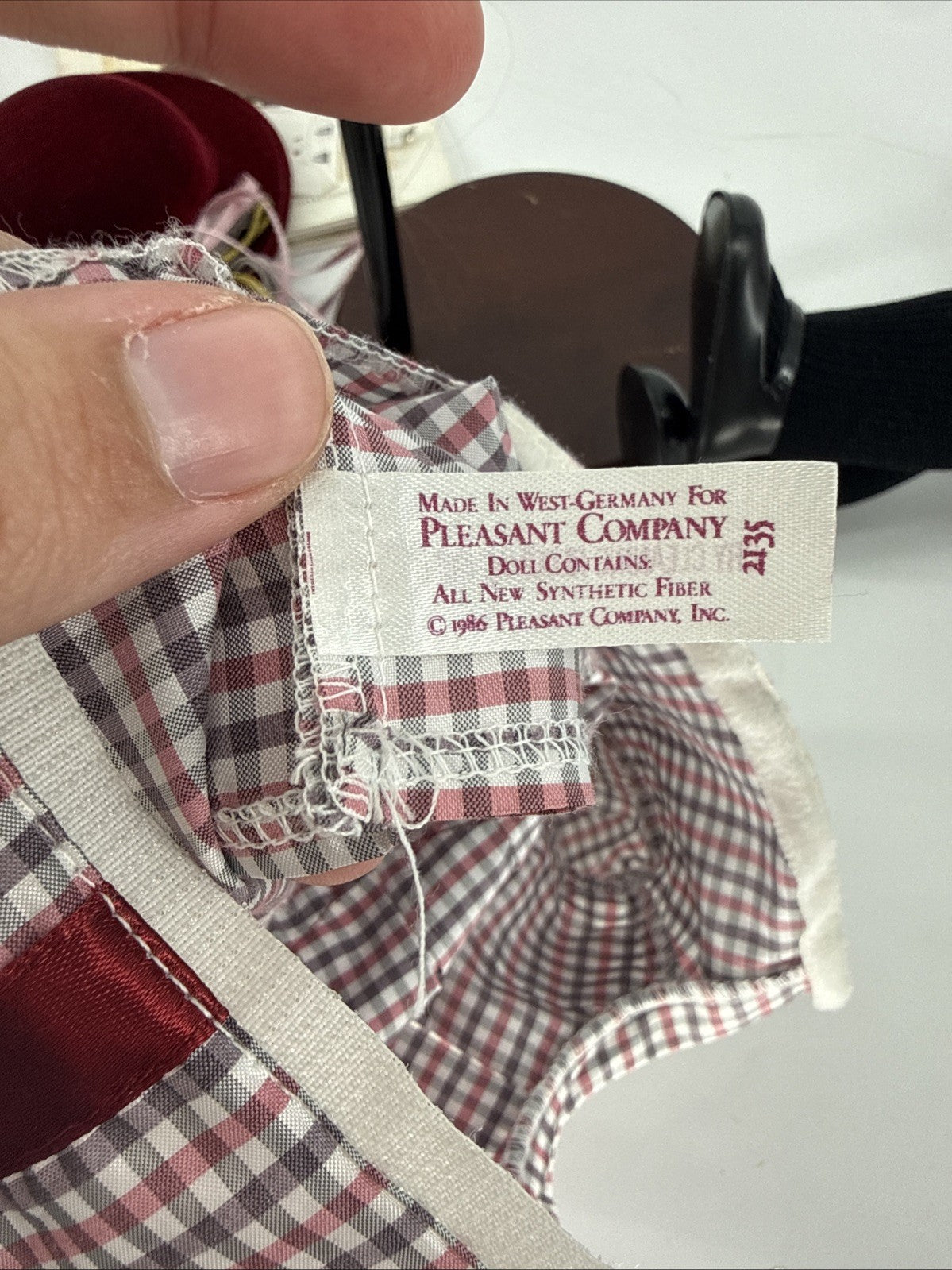 Close-up of a label on a doll's outfit with 'Pleasant Company' branding.