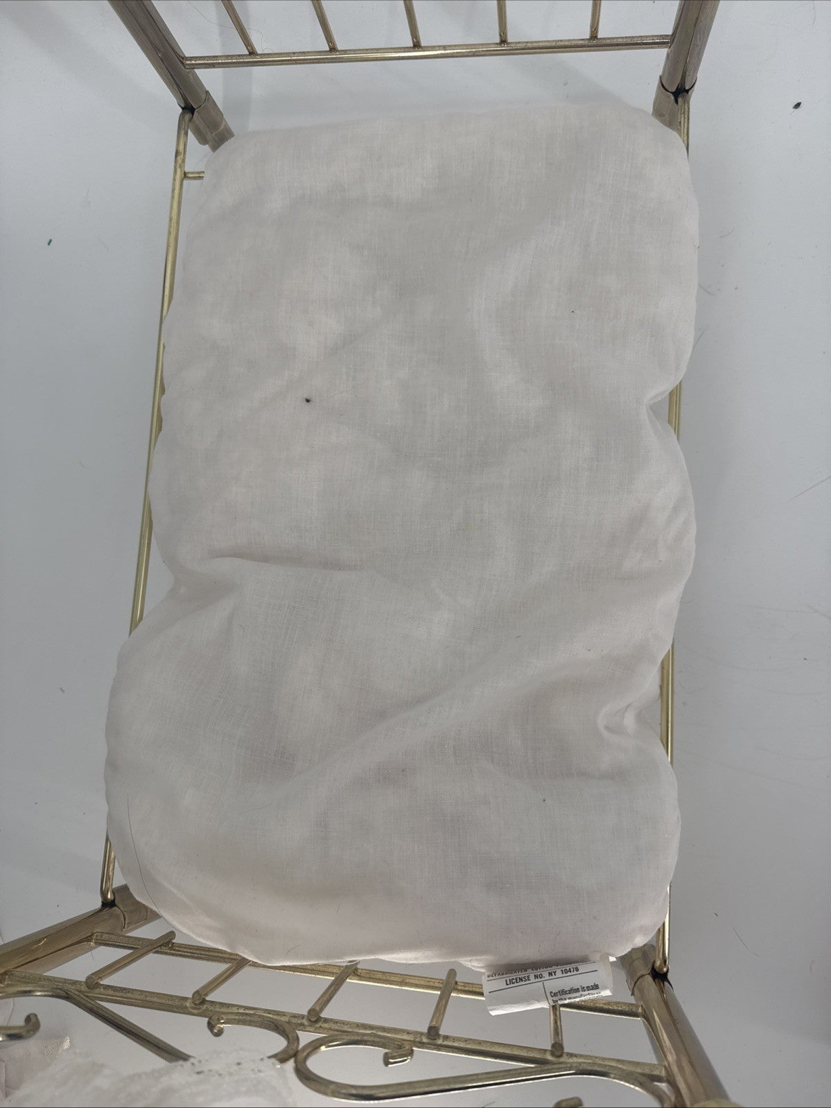White cushion on a metal frame against a white background