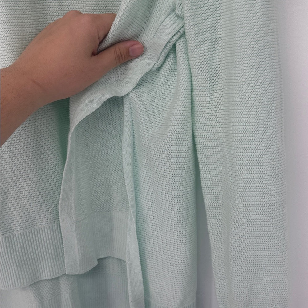 Light green textured fabric with a hand holding it