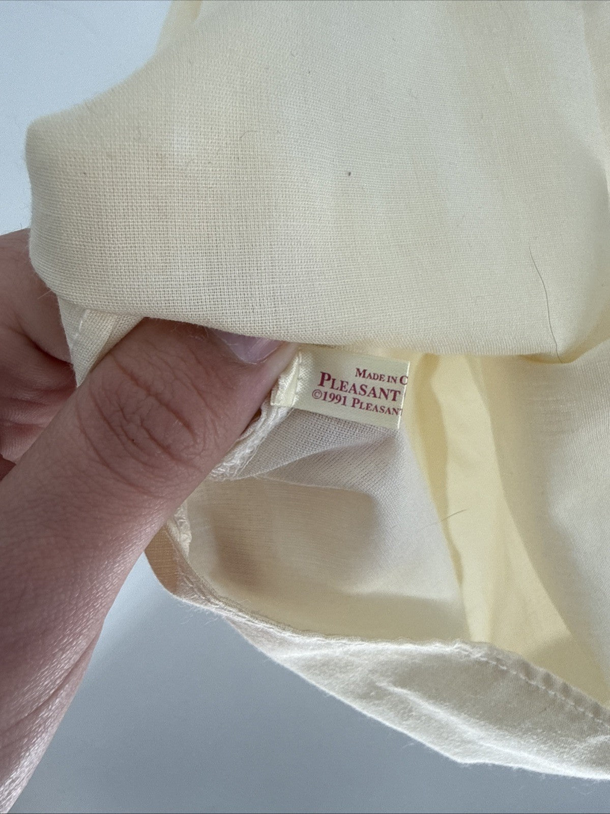 Close-up of a beige garment with a label on a light gray background