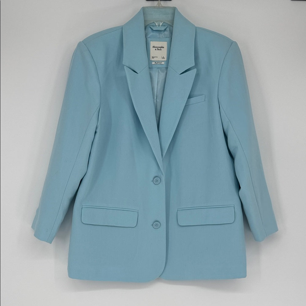 Light blue blazer on a hanger against a white background